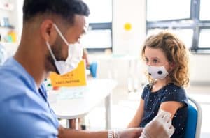 A child gets a vaccine from a medical provider.